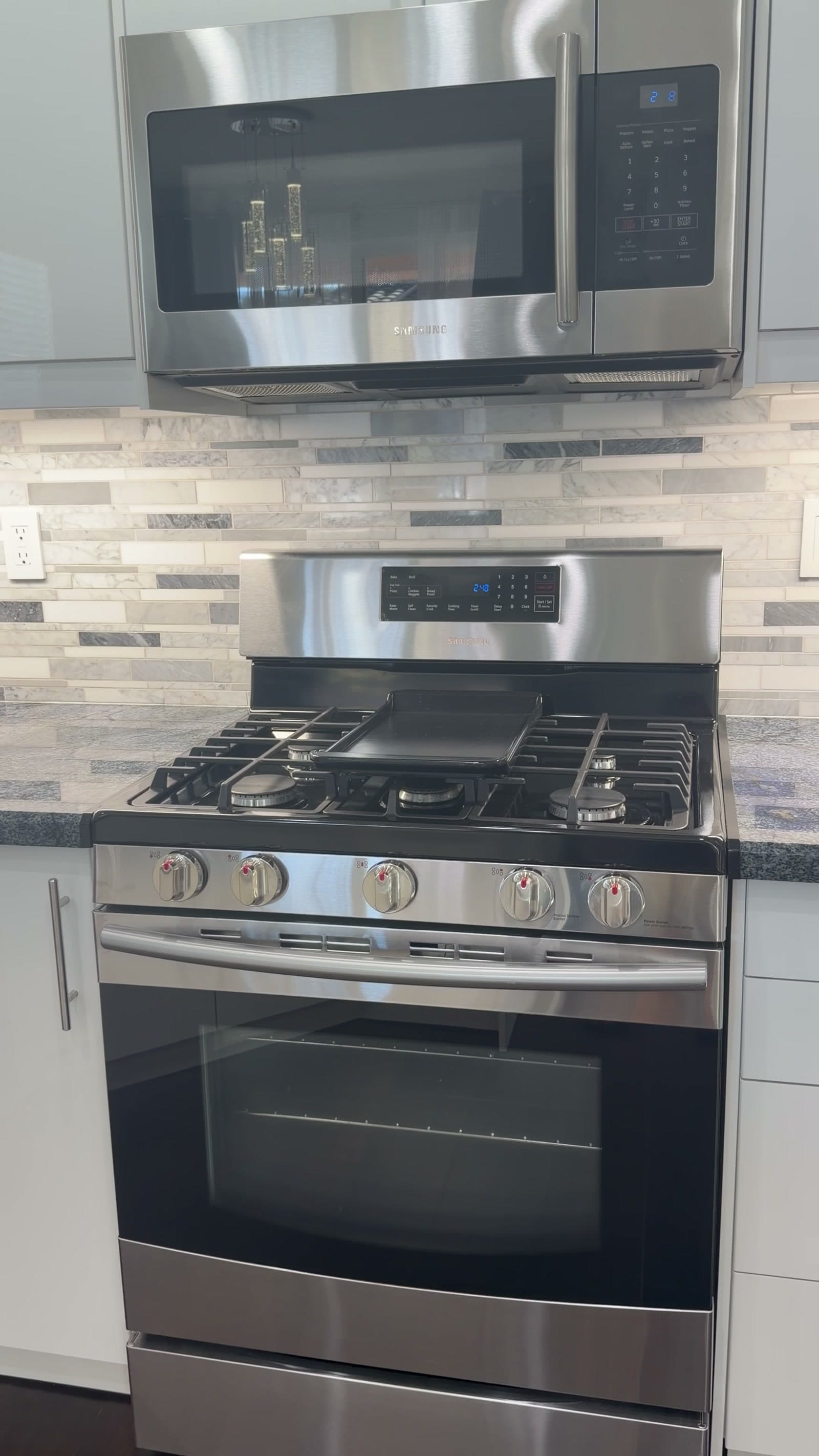Kitchen cabinetry, counters, and stainless steel appliances at 52 Marcilla
